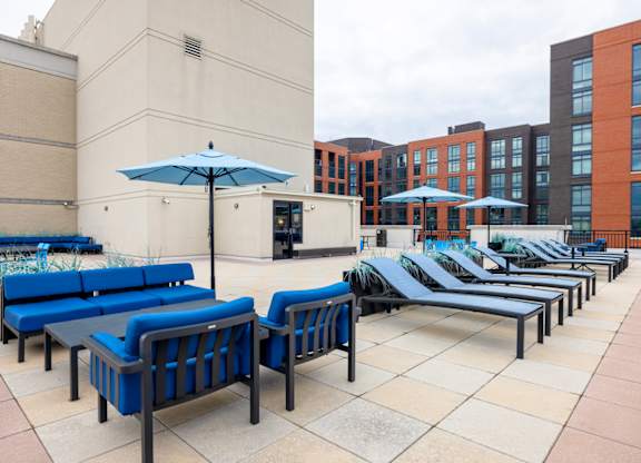 A patio with blue couches and umbrellas. at Loree Grand at Union Place, Washington, DC