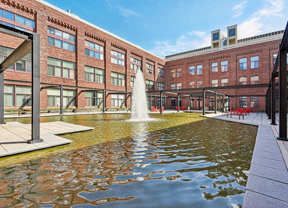 A fountain in the middle of a courtyard surrounded by buildings.