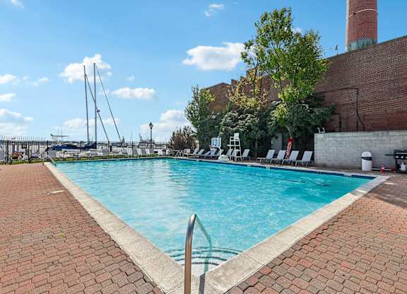 A large outdoor swimming pool with a brick border.