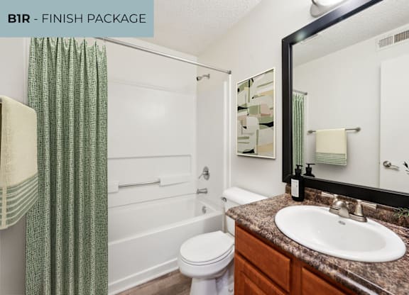 A bathroom with a white toilet, a sink, and a shower.