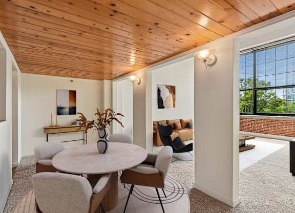 A dining room with a round table and chairs.