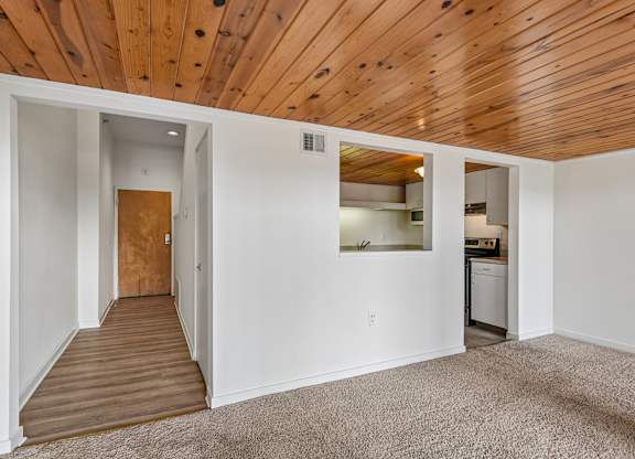 A room with a wooden ceiling and a carpeted floor.