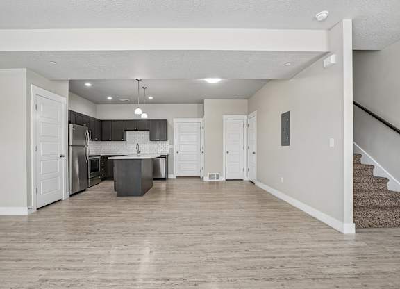 A kitchen with a refrigerator, sink, and stove is visible in the image.