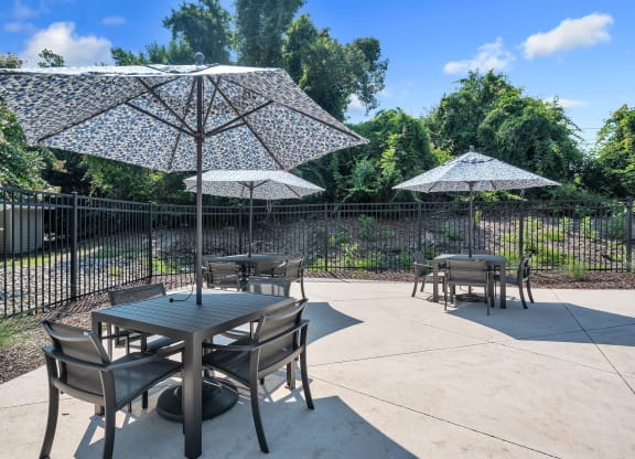 a patio with tables and umbrellas and a fence at St. Andrews Reserve, Wilmington, North Carolina