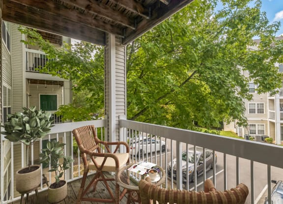 a porch with two chairs and a table on a balcony at Sanger Place, Lorton, VA