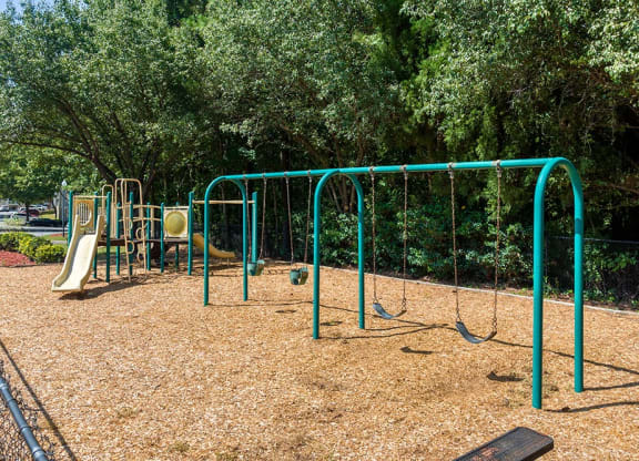 a playground with a swing set and other playground equipment at Alexander Ridge Apartments, Canton