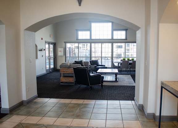 A large room with a black couch and a table at Arrowhead Ridge Apartments, New Mexico 87124
