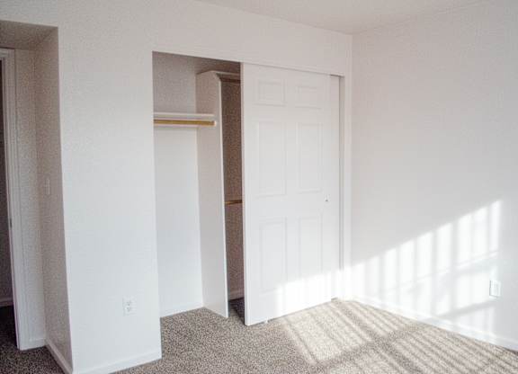 A white door is in a white room with a tan carpet at Arrowhead Ridge Apartments, Rio Rancho, NM