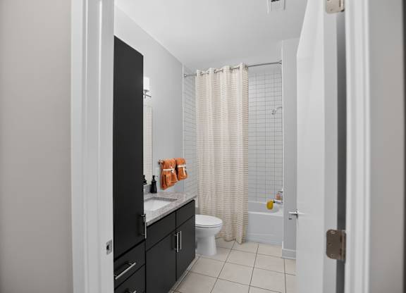 A bathroom with a white toilet and a shower with a white curtain.