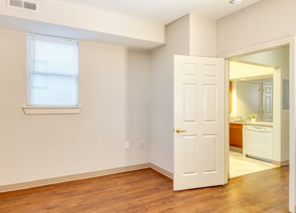 a bedroom with a door and a bathroom with a mirror at North Market South Carroll, Frederick, MD 21701