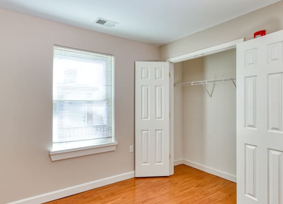 an empty bedroom with a closet and a window and a door at North Market South Carroll, Frederick, MD