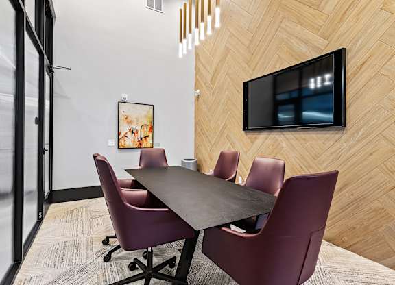 A conference room with a long table and chairs.