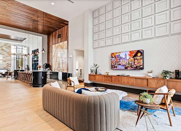 Clubhouse lounge space with couch and tv at Preston Ridge Apartments in Cary, NC.