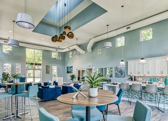 A modern open plan living and dining area with a kitchen in the background.