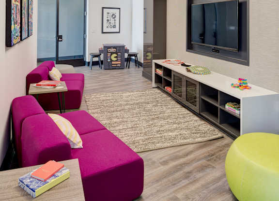a living room with a purple couch and a television at Fort Totten Square, Washington, 20011