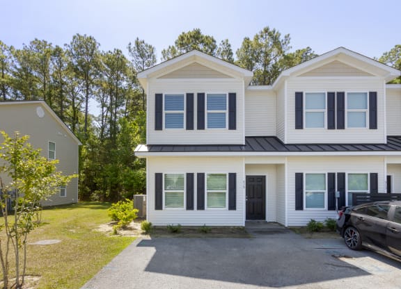 the front of the house with a car in the driveway and trees in the background  at Waverly Place, South Carolina