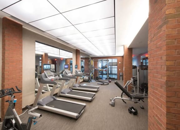 a gym with treadmills and weights in a large room at Reed Row, Washington DC