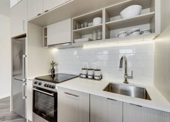 a white kitchen with a sink and a refrigerator at Reed Row, Washington, DC
