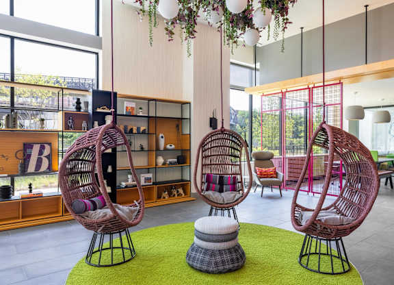 a lobby with two rattan chairs and a green rug at Coda at Bryant Street, Washington, DC