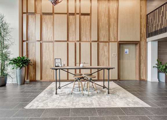 a dining room with a table and chairs in front of a wood wall at Coda at Bryant Street, Washington, DC