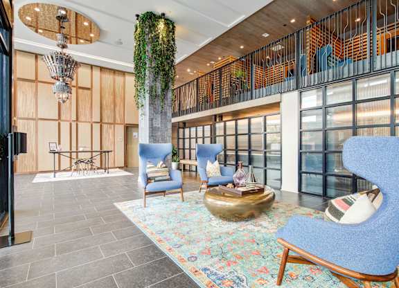 a lobby with blue chairs and a gold sculpture in the middle at Coda at Bryant Street, Washington, DC 20002