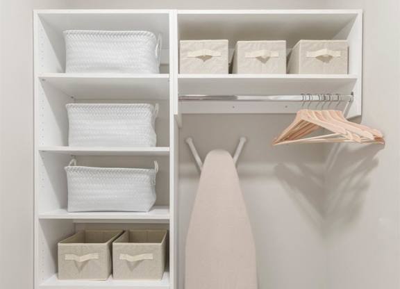 a walk in closet with shelves and a white shelf with a surfboard in it at Coda at Bryant Street, Washington, DC 20002