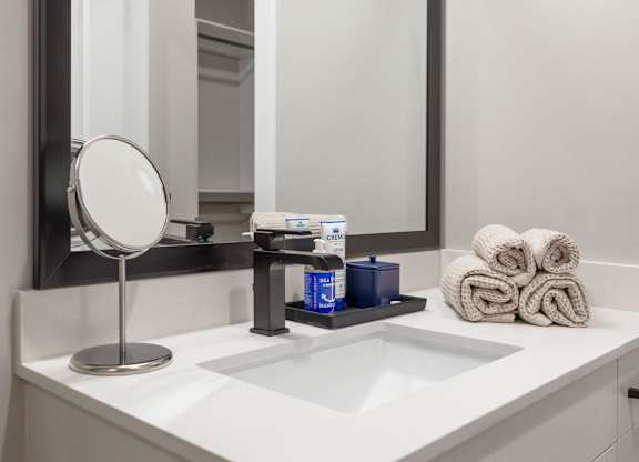 a bathroom with a sink and a mirror and towels at Coda at Bryant Street, Washington, DC