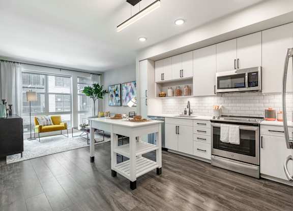 a kitchen with white cabinets and stainless steel appliances at Coda at Bryant Street, Washington