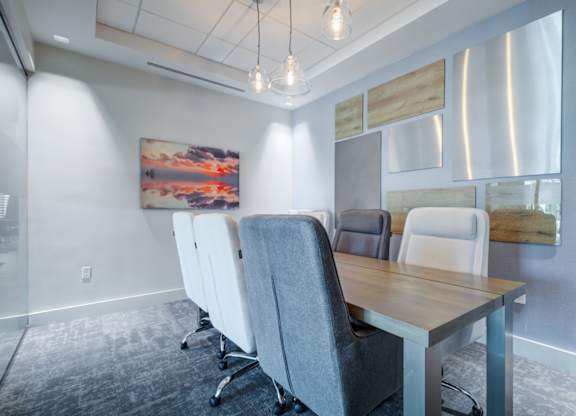 A conference room with a long table and chairs.