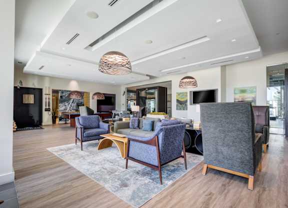 A modern living room with a grey sofa and wooden floors.