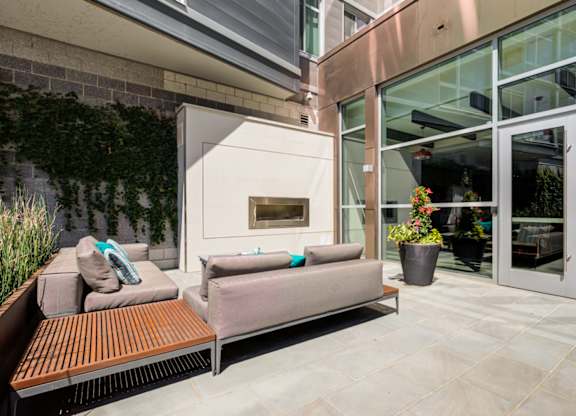 A patio with a couch and a fireplace.