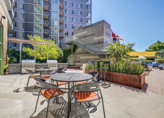 A patio with a table and chairs is surrounded by buildings.