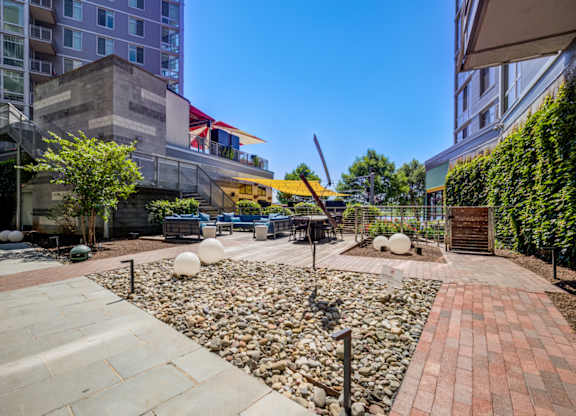 A sunny day in a courtyard with a mix of stone and brick surfaces.