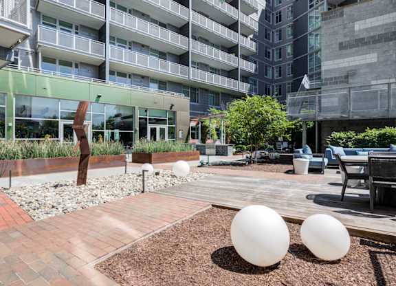 A modern courtyard with two large white spheres in the foreground.