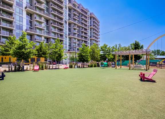 A park with a green lawn and a playground.