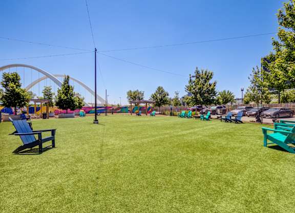 A park with a blue bench and a green bench in the foreground.