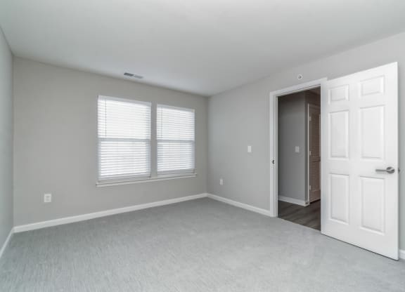 an empty bedroom with a white door and window at The Fields at Lorton Station, Lorton, VA