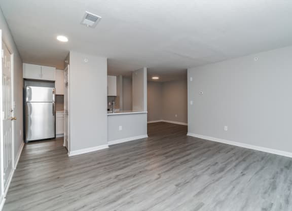 an empty living room and kitchen with a refrigerator and at The Fields at Lorton Station, Lorton, 22079