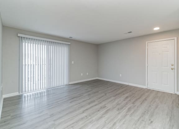 an empty living room with a large window and a door at The Fields at Lorton Station, Lorton, Virginia