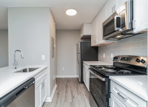 an empty kitchen with white cabinets and stainless steel appliances at The Fields at Lorton Station, Virginia, 22079