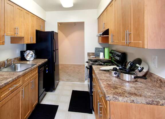 A kitchen with brown cabinets and granite countertops.
