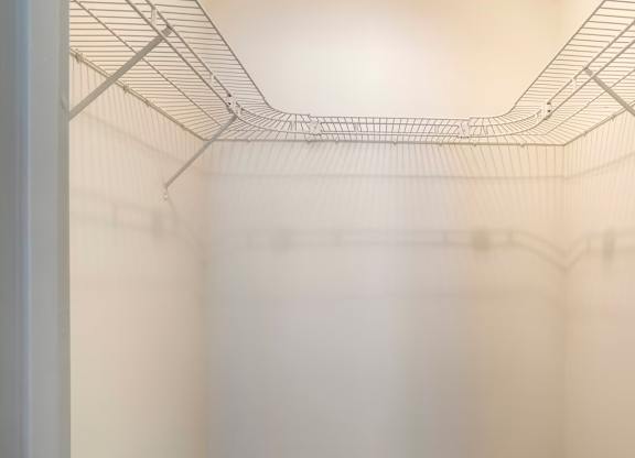 Empty wire shelving in a white fridge.
