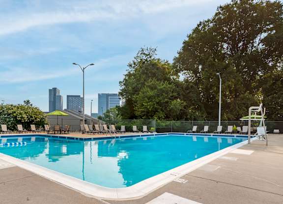 A large swimming pool with a city skyline in the background.