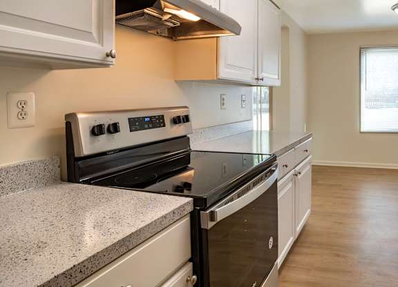 A kitchen with a stove top oven and a refrigerator.
