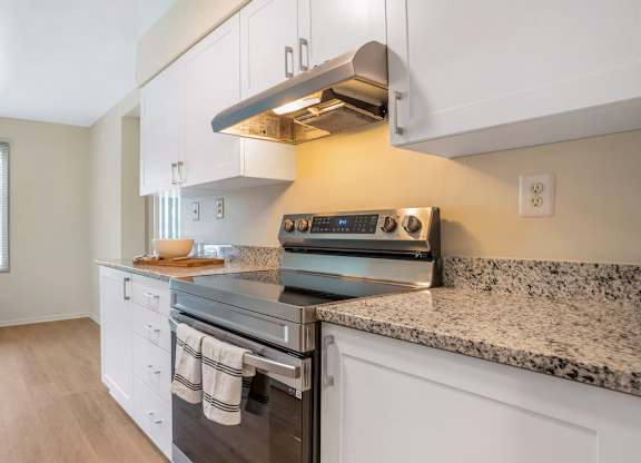 A kitchen with a stove top oven and a window.
