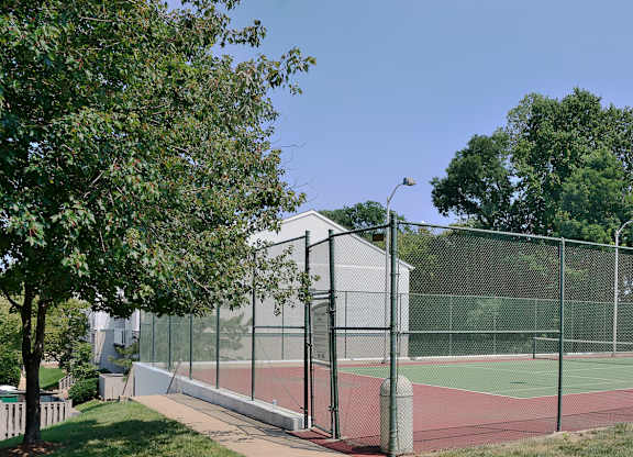 A tennis court is enclosed by a chain-link fence.