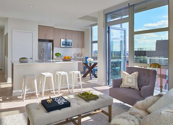 A modern living room with a bar area and a view of the city.