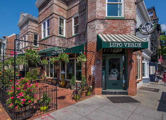 A brick building with a green awning that says