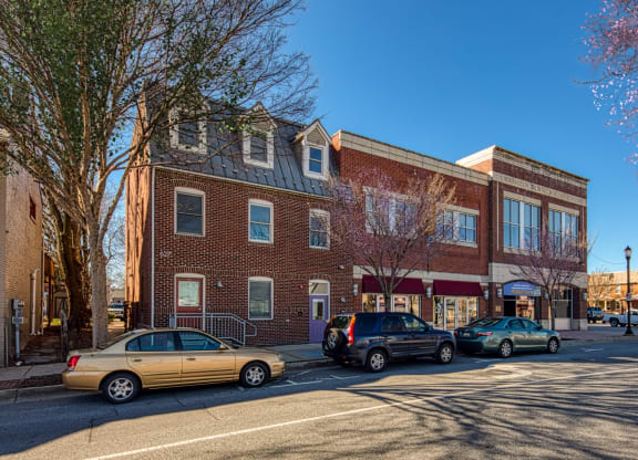 a city street with cars parked in front of a brick building at North Market South Carroll, Frederick Maryland