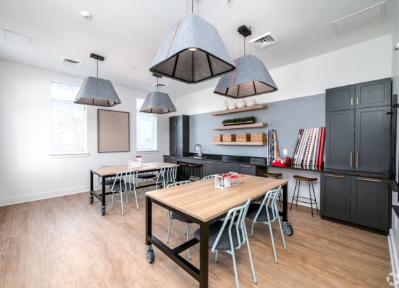 a dining room with tables and chairs and a kitchen at Fairmont at South Lake, Bowie